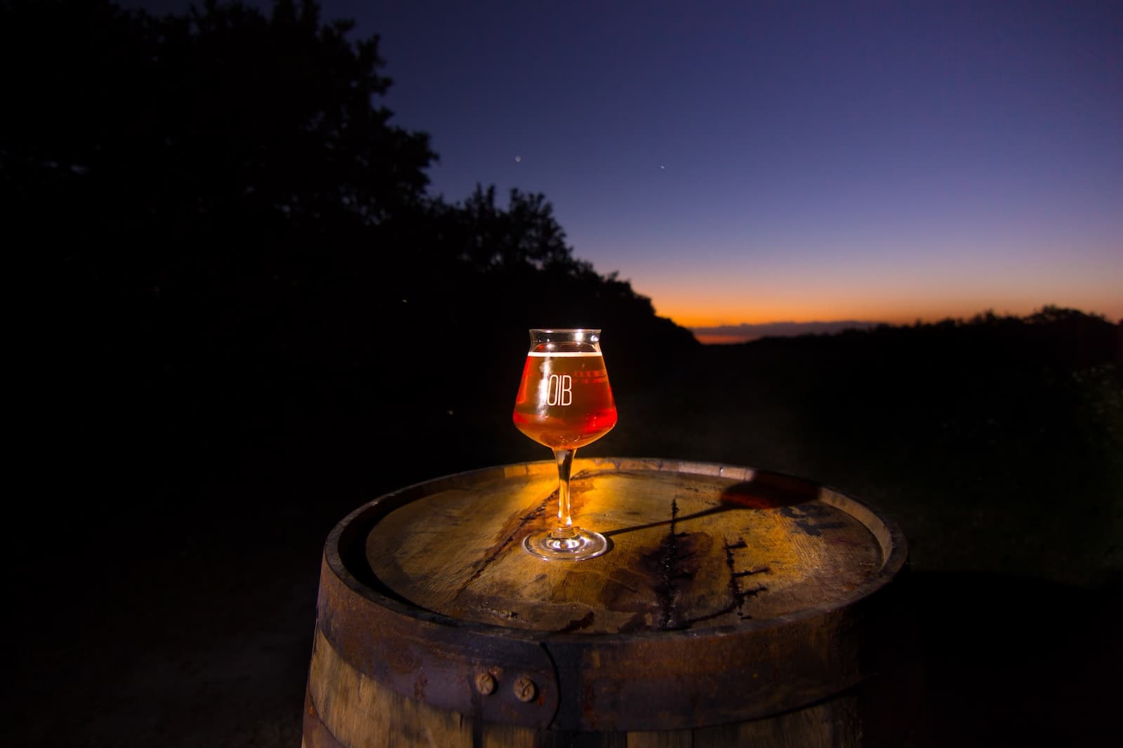 Orchid Island Brewery beer on a barrel at dusk